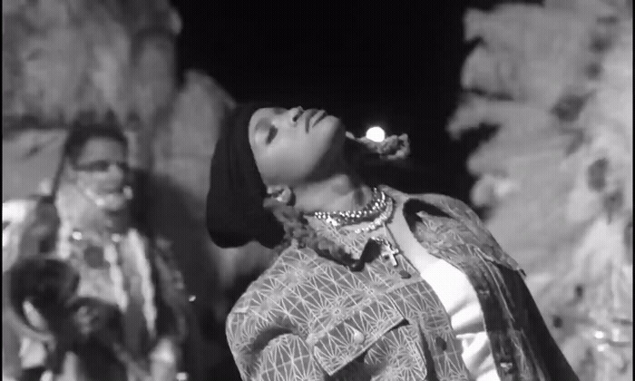 a black and white photo of a woman singing into a microphone