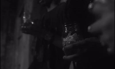 a black and white photo of a person holding a drink