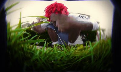 a man with red hair sitting in the grass