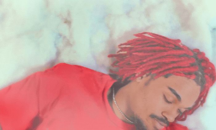 a man with red dreadlocks laying on a bed