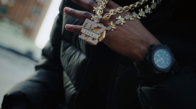 a person wearing a gold chain and a watch