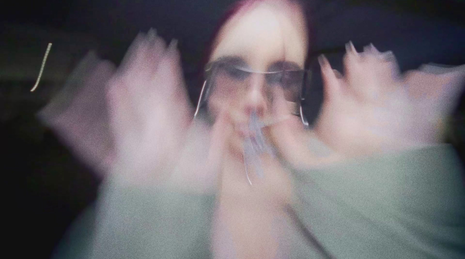 a blurry photo of a woman with her hands in the air