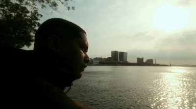 a man sitting next to a body of water