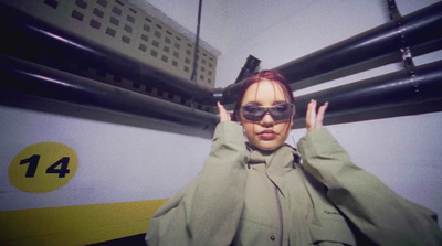 a woman wearing sunglasses standing in front of a train