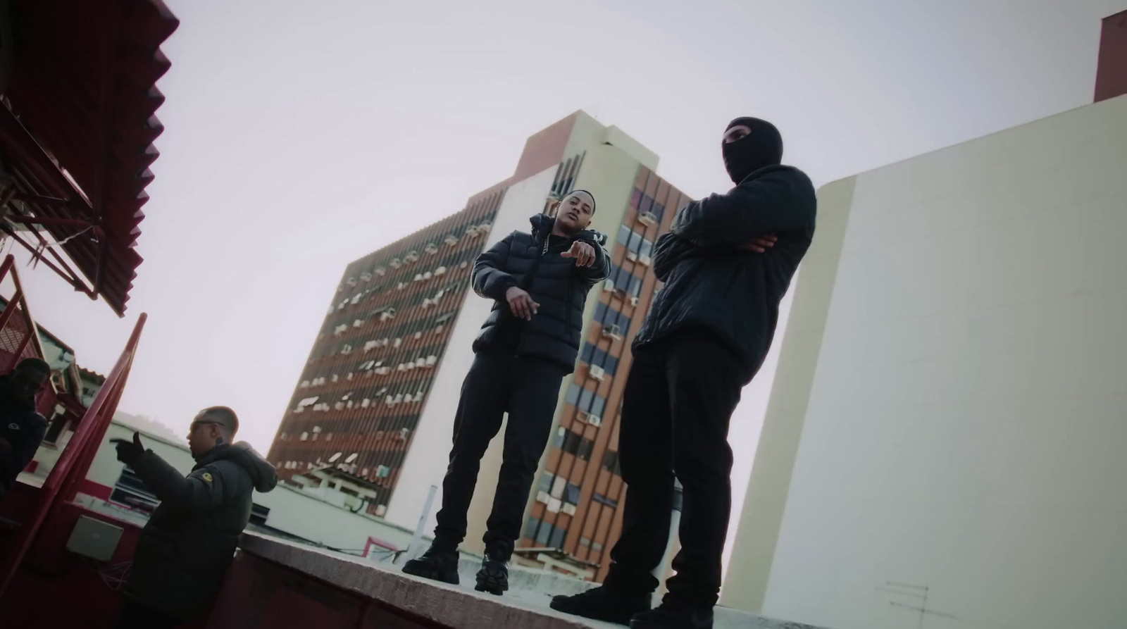 two people standing on a ledge in front of a tall building