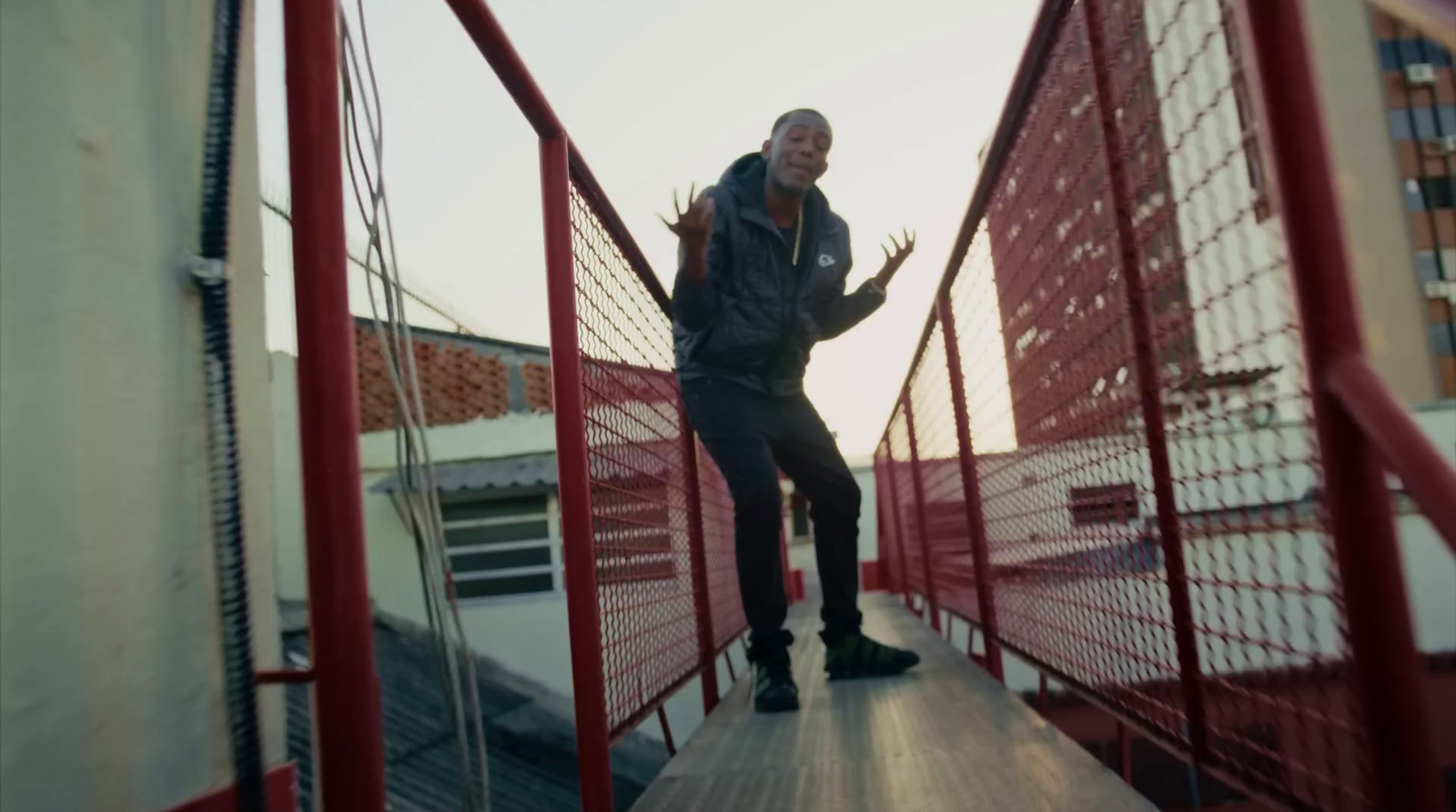 a man is standing on a red fence