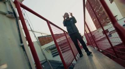 a man standing on top of a red fence