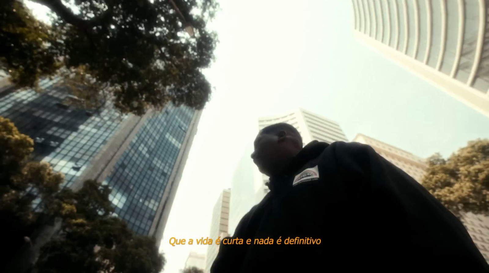 a man standing in front of tall buildings