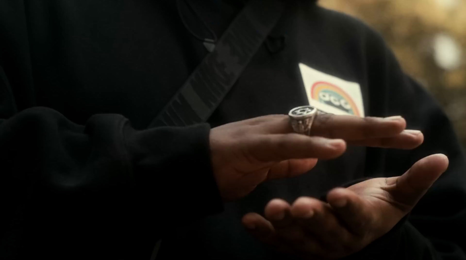a man wearing a ring holding a playing card