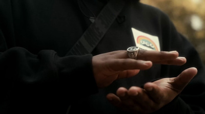 a man wearing a ring holding a playing card