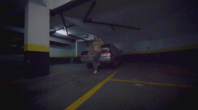 a man standing next to a car in a parking garage