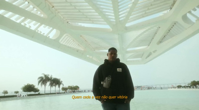 a man standing under a white structure with palm trees in the background