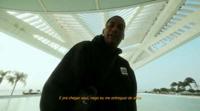 a man standing under a white roof next to a body of water