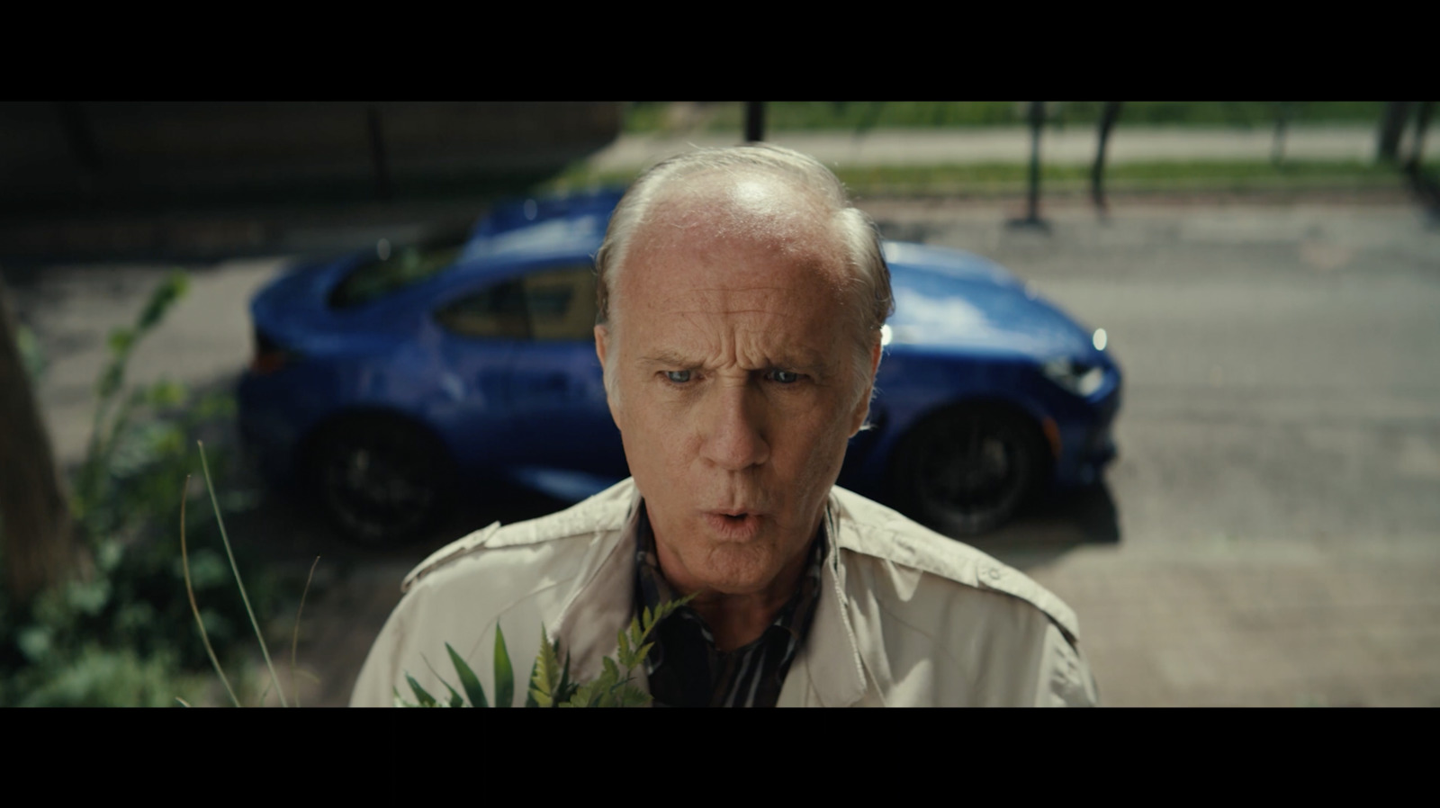 a man standing in front of a blue car