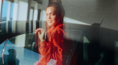 a woman in a red shirt is sitting at a table