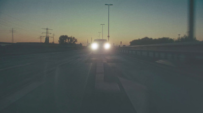 a car driving down a highway at dusk