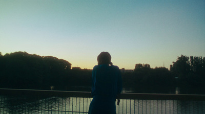 a person standing on a bridge looking at the water