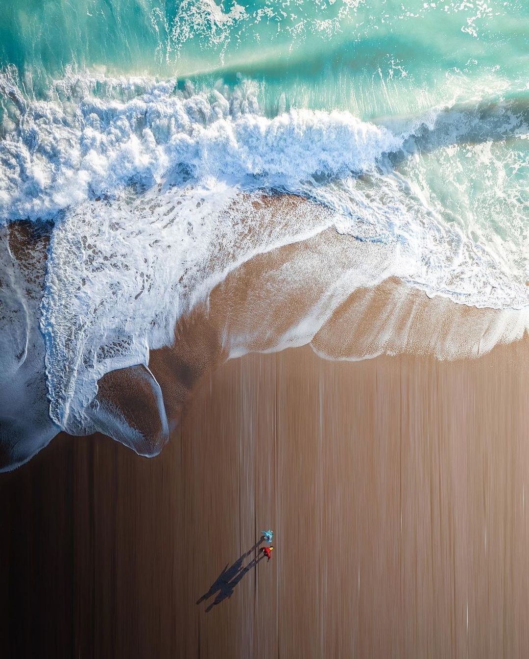 an aerial view of a surf boarder riding a wave