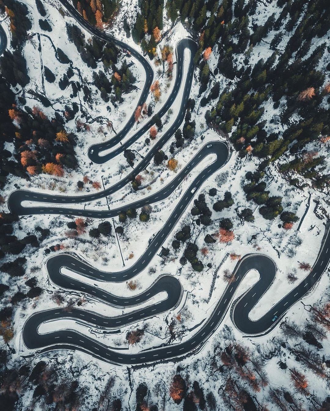 an aerial view of a winding road in the snow