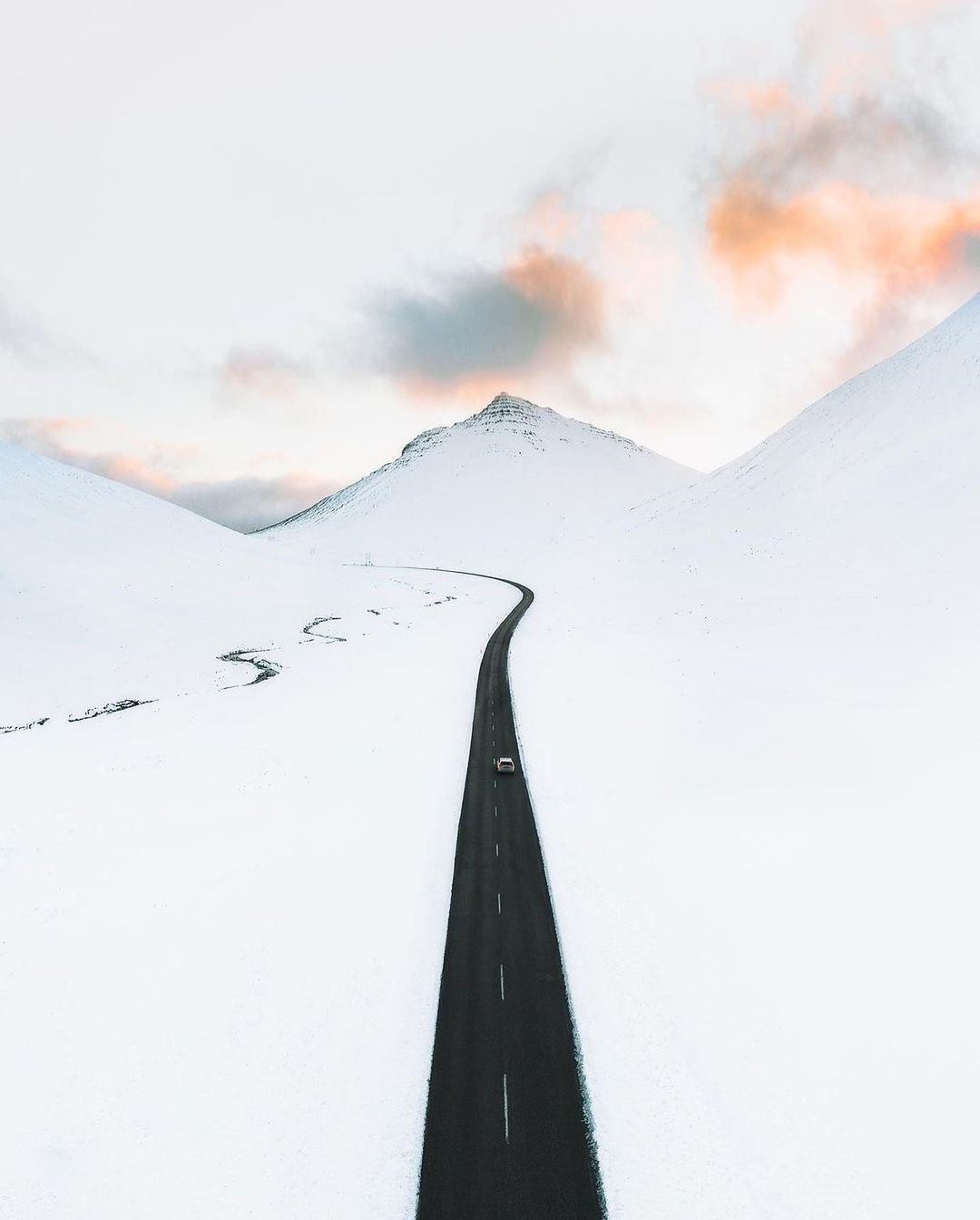 a car driving down a snow covered road