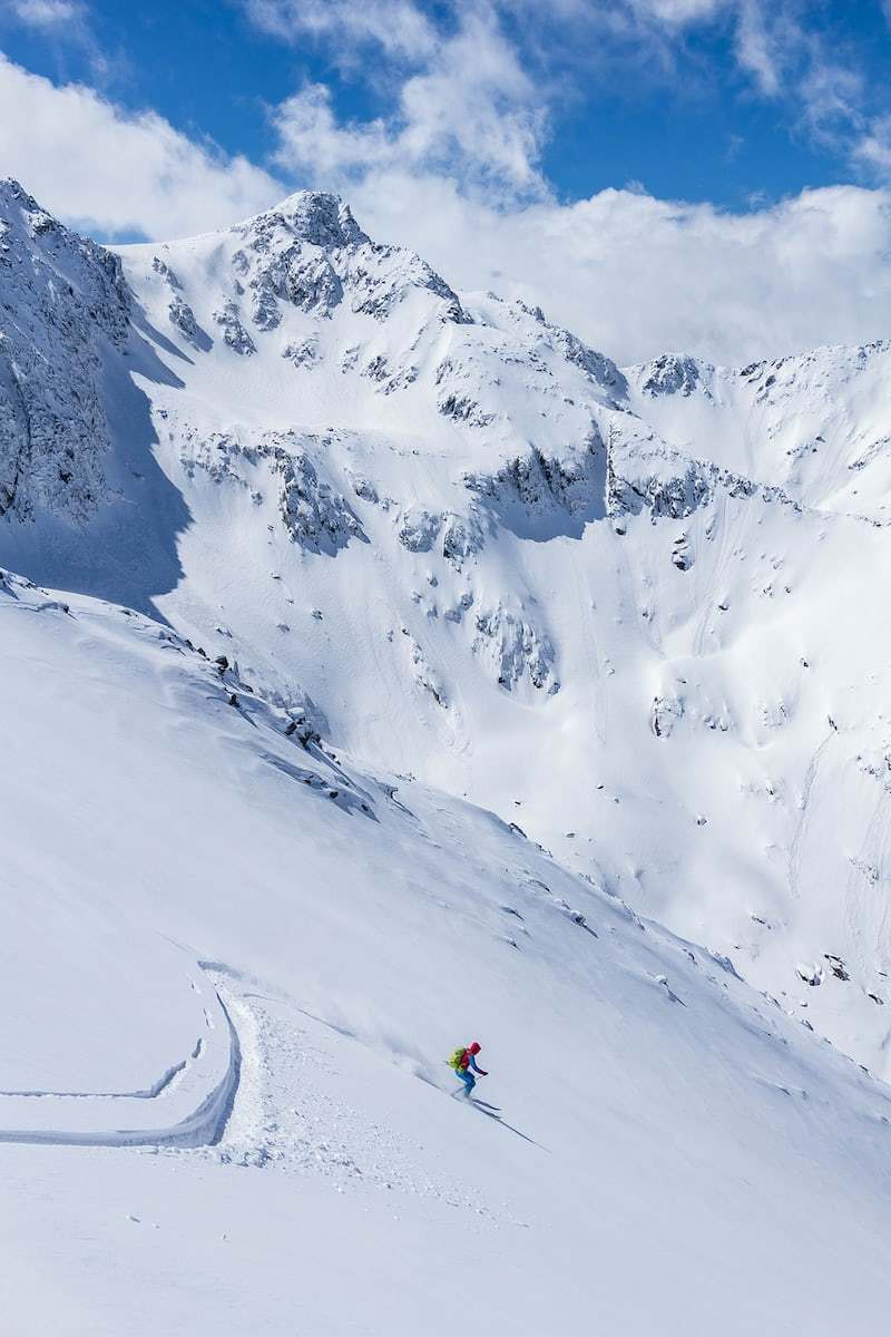 a man riding skis down a snow covered slope