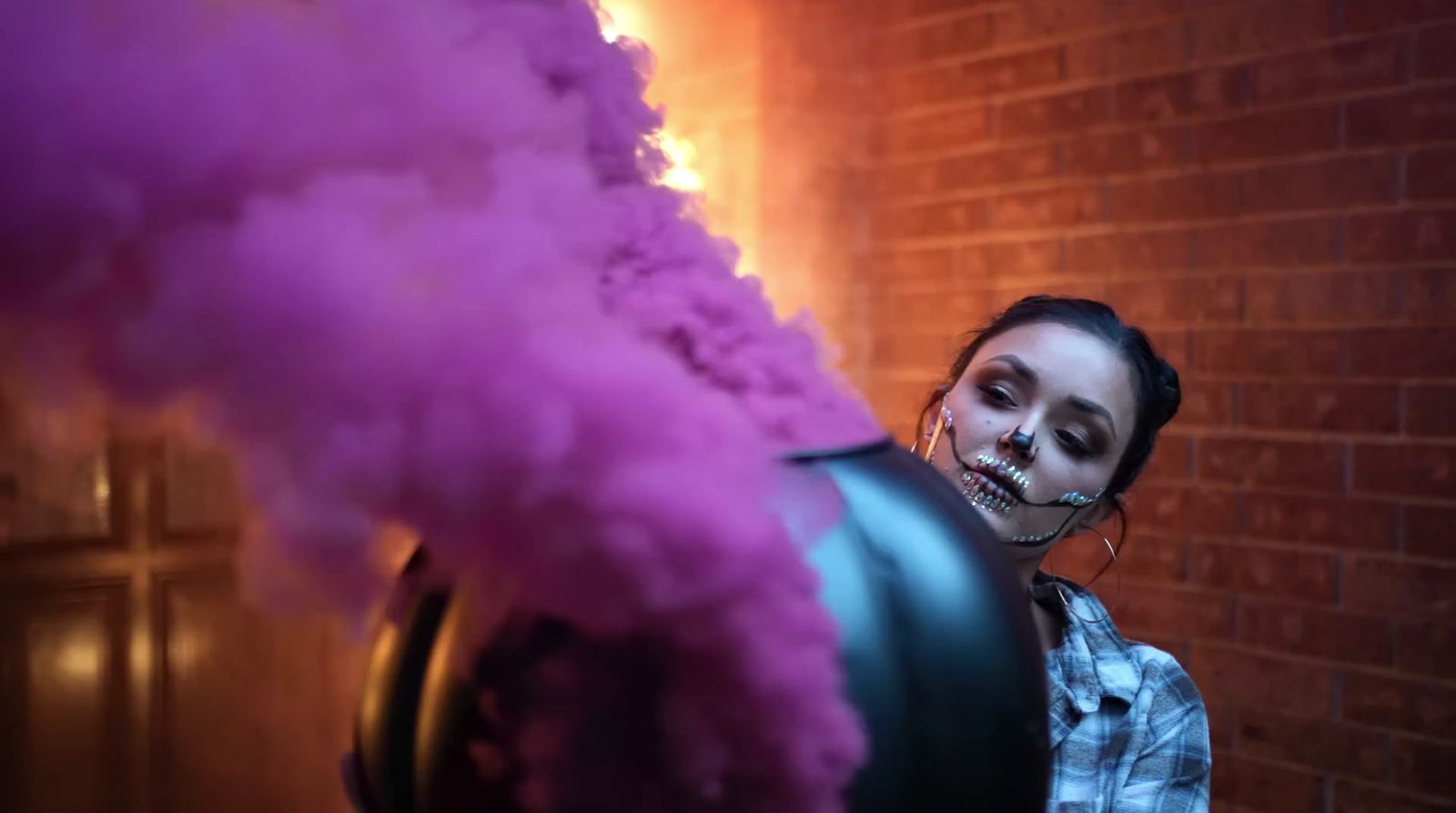 a woman with makeup on her face is smoking a pipe