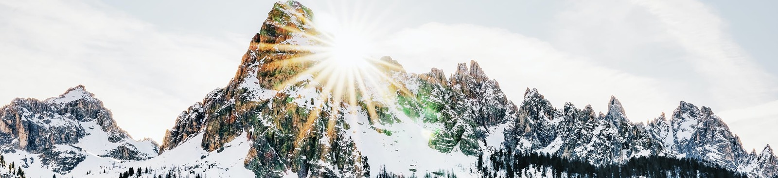 the sun shines brightly over a snowy mountain