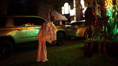 a woman dressed in a costume standing next to a car