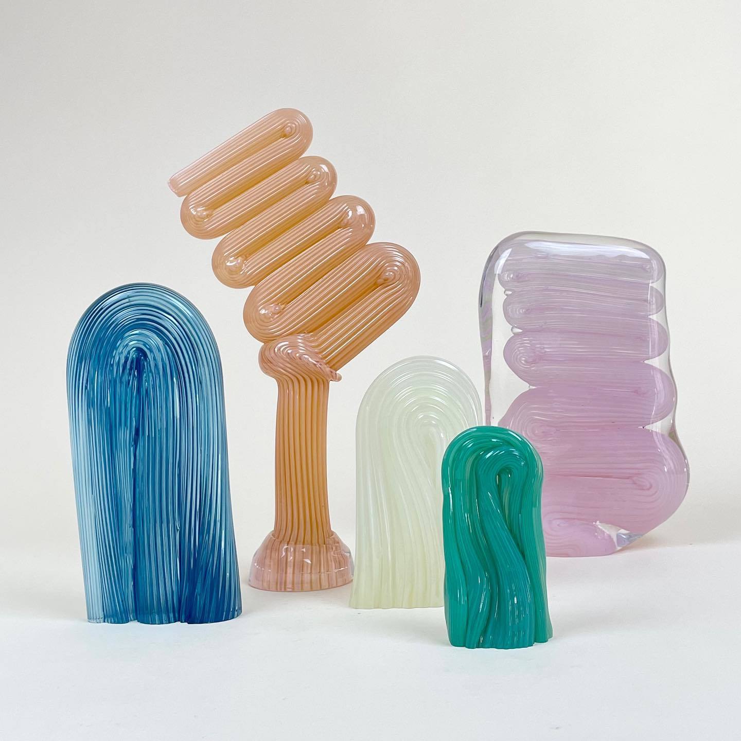 a group of three different colored vases sitting next to each other