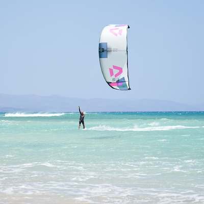 a person windsurfing in the ocean on a sunny day