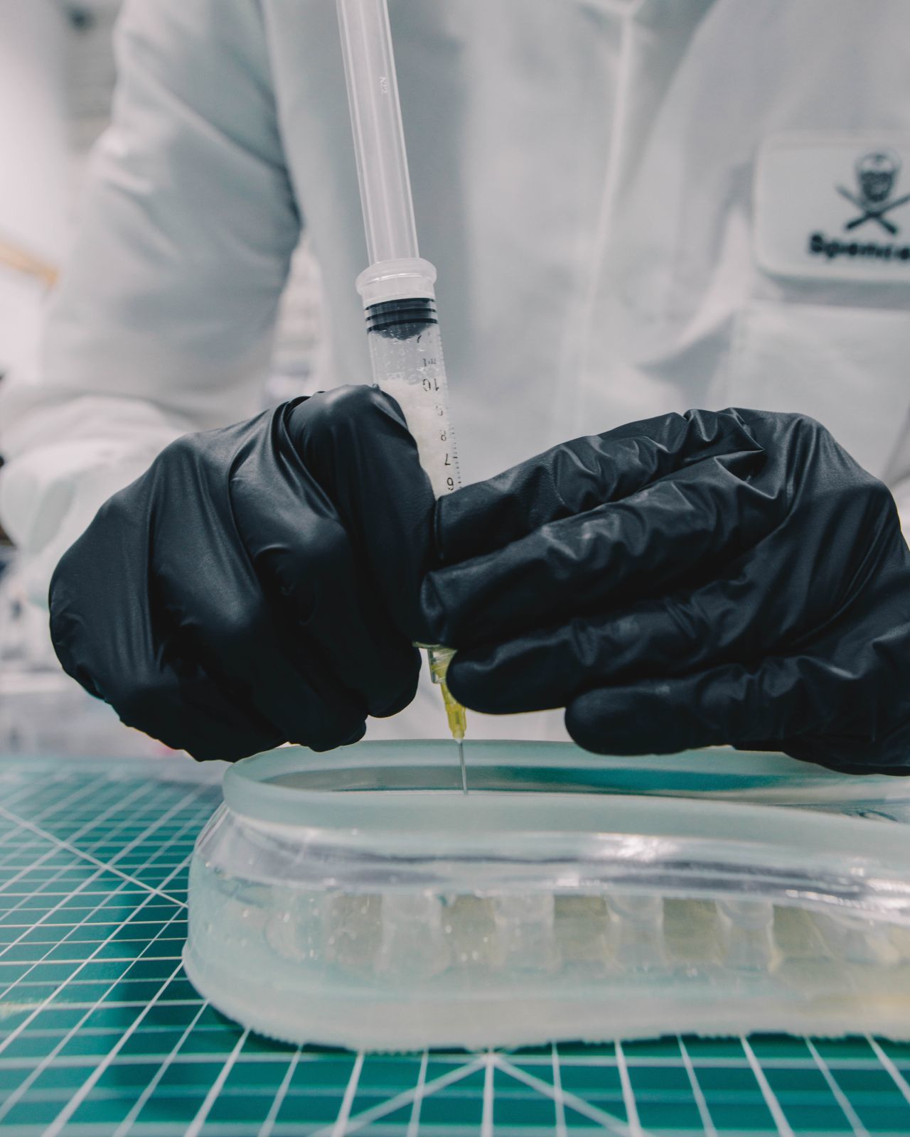 a person in a white coat and black gloves