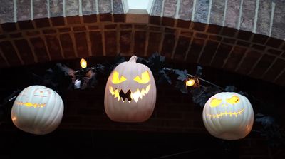 a couple of pumpkins hanging from a brick wall