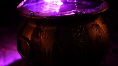 a water fountain with a purple light in the background