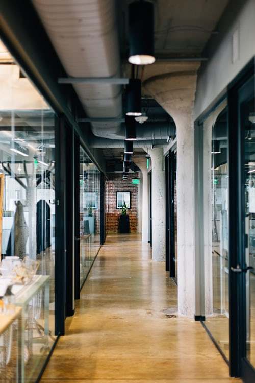 a long hallway in a building with glass walls