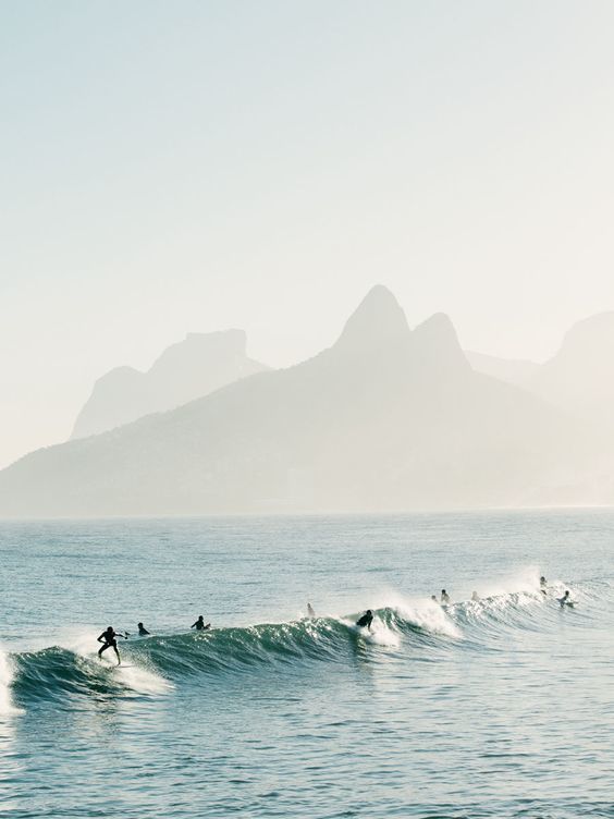 a group of people riding surfboards on top of a wave