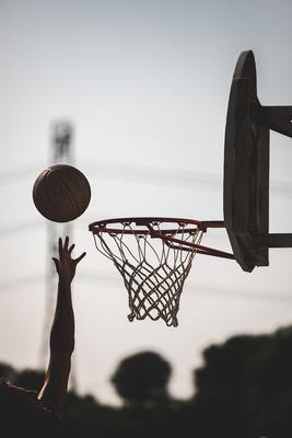 a person reaching for a basketball in the air