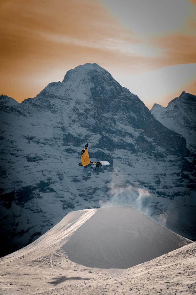 a man flying through the air while riding a snowboard