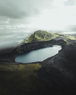 an aerial view of a mountain with a lake in the middle