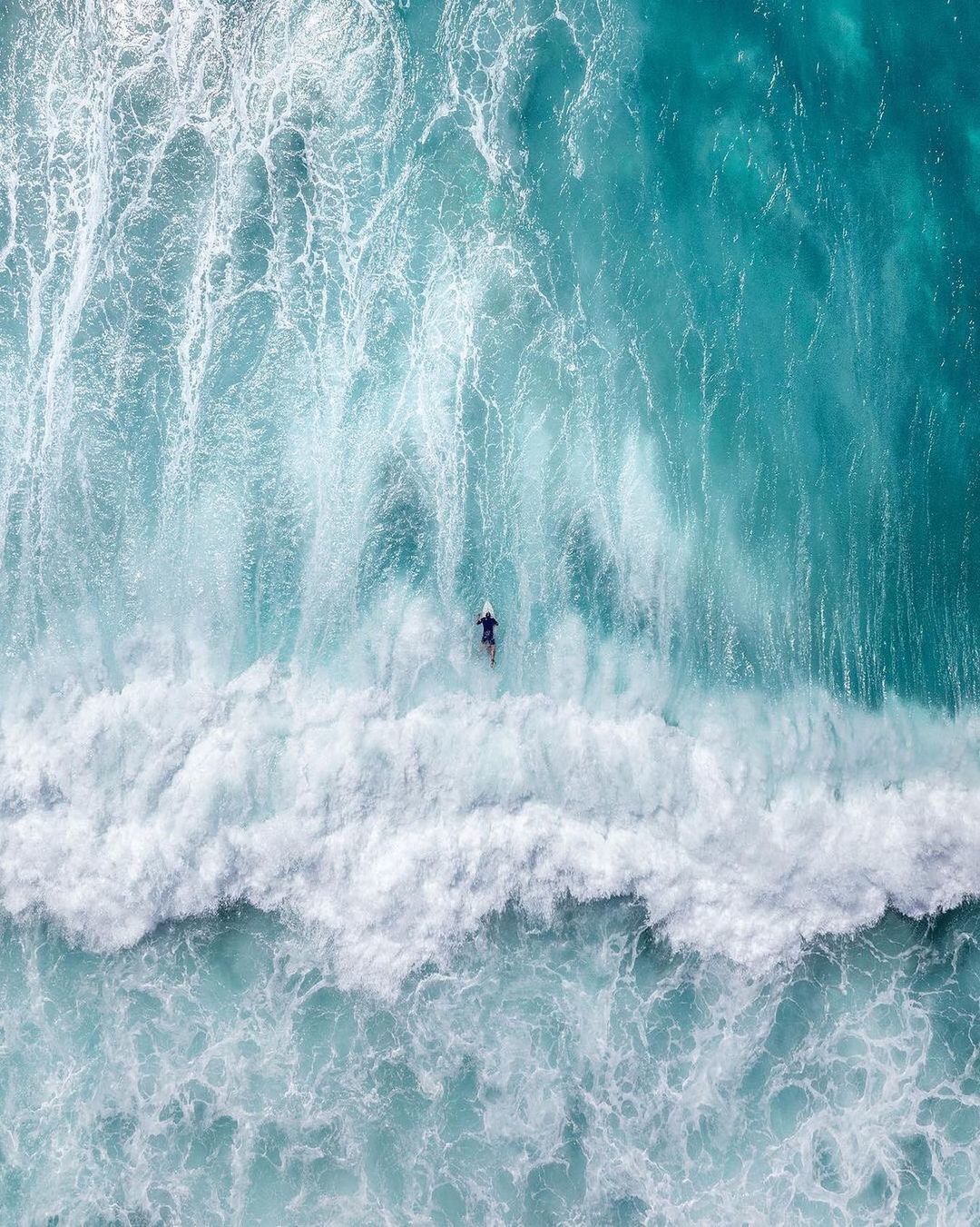 a man riding a wave on top of a surfboard