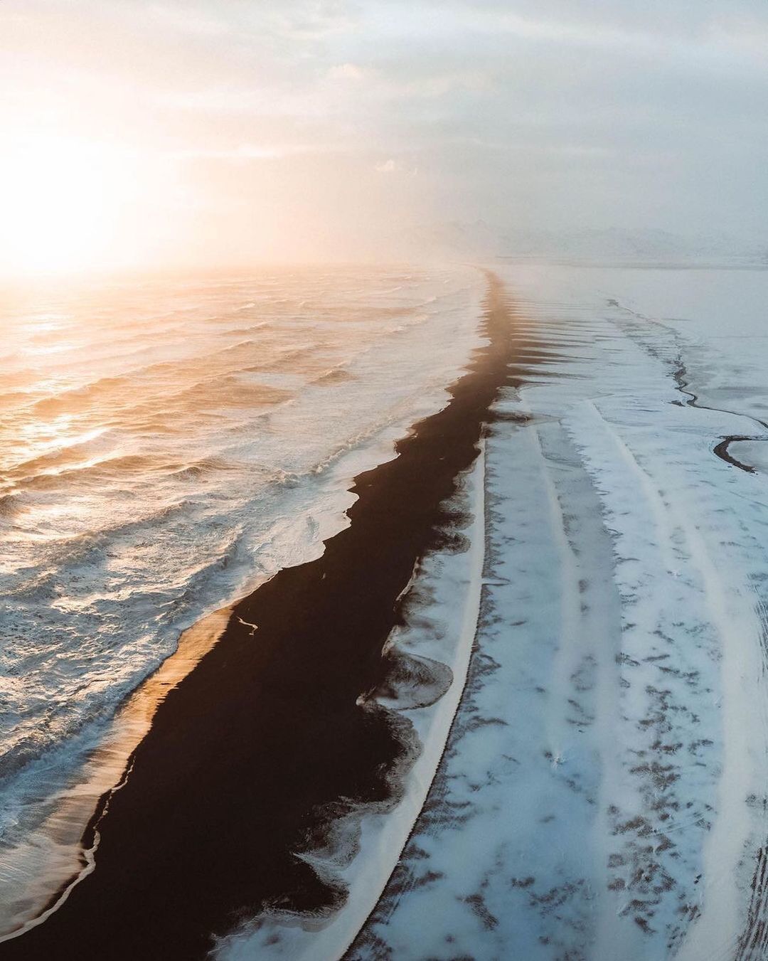 an aerial view of a beach covered in snow