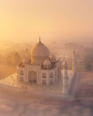 an aerial view of a white building in the middle of fog