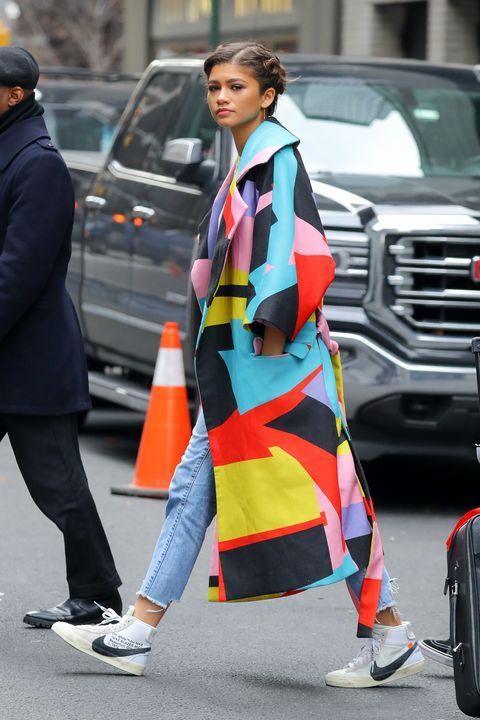 a woman in a colorful coat walking down the street