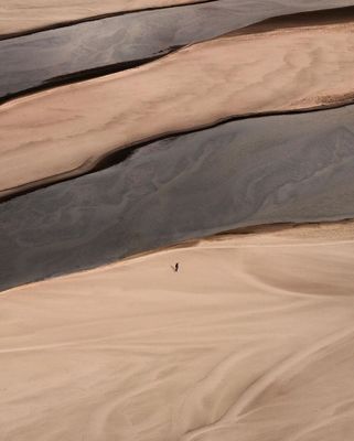 a person walking across a sandy area in the desert