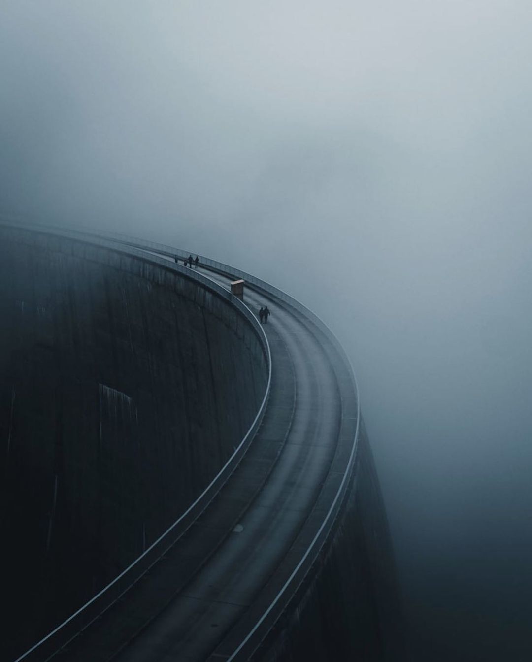 a car driving down a road in the fog