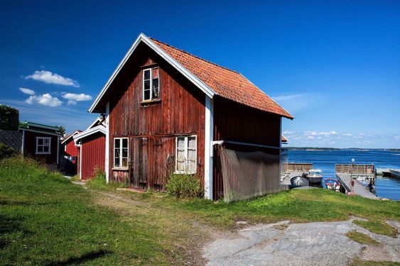 a red house sitting next to a body of water