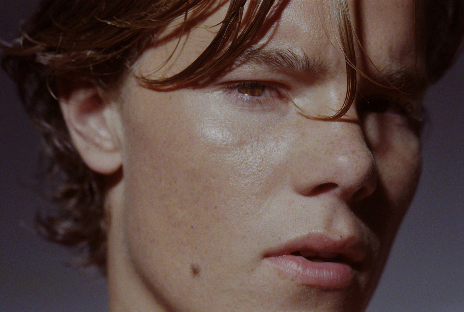 a close up of a young man with frizz on his face