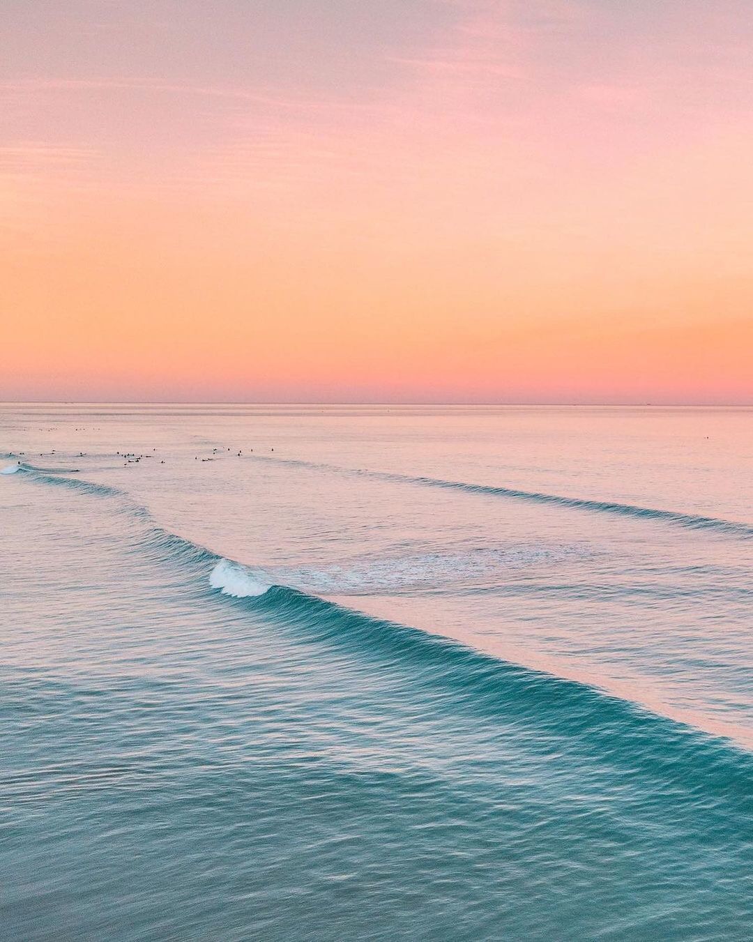 a group of people riding surfboards on top of a wave