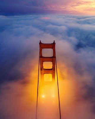 a picture of the golden gate bridge in the clouds