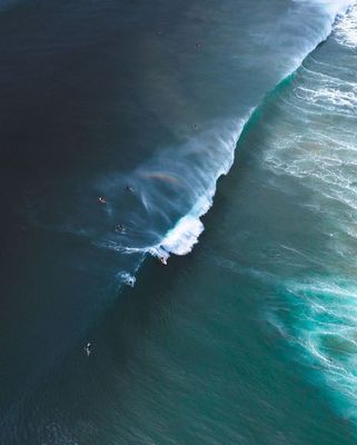 a group of people riding surfboards on top of a wave