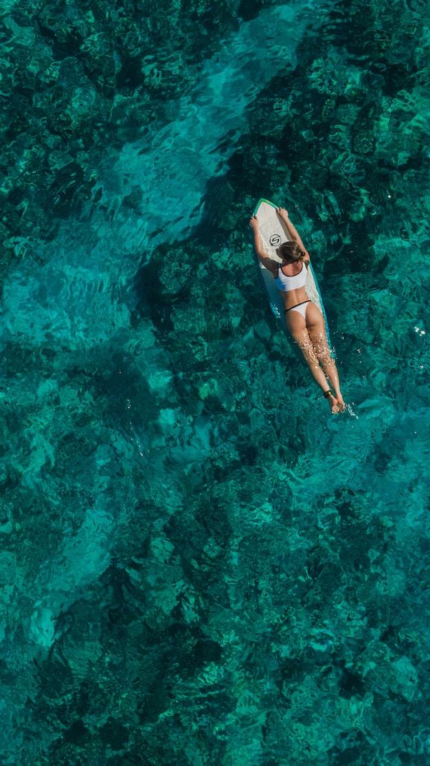 a woman in a bikini on a surfboard in the ocean